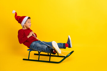 Full body photo of adorable small schoolboy sled have fun winter vacation stylish red knitted...