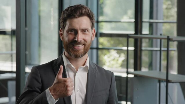 Business portrait in office success confident ambitions middle-aged boss employer showing thumb up gesture adult Caucasian 40s bearded man CEO businessman recommend approve excellent good support sign