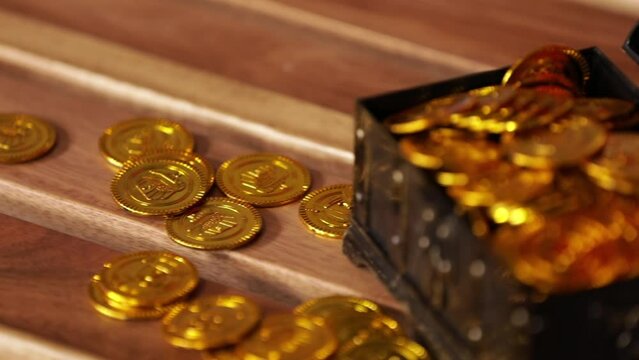 Gold coins in treasure box on wood table