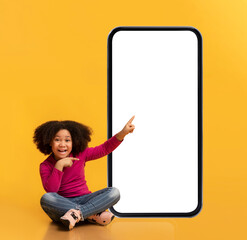 Cute Black Little Girl Pointing At Big Blank Smartphone With White Screen