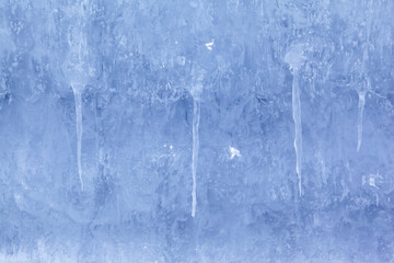 Texture of winter ice on a stone cliff. Blue natural ice background