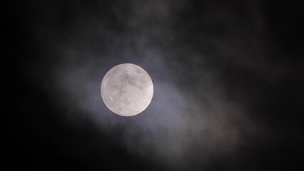 Naklejka na ściany i meble Full moon in clouds in California sky.