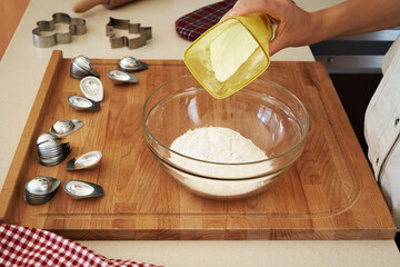 Woman preparing Christmas cookies - pouring sugar into a bowl