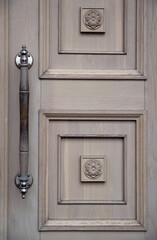 Old wooden door. The concept of minimalism and history. Details of classical architecture.