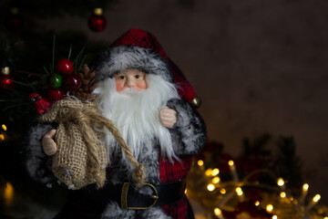 Forest wizard or Santa Claus close-up against the background of a Christmas tree and lights