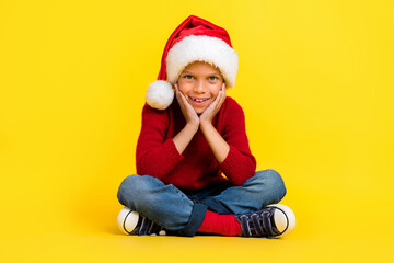 Full size photo of cute small boy sit floor enjoy christmas new year dressed stylish red knitted outfit isolated on yellow color background