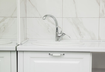 A water tap with a sink in a modern kitchen. the interior is made of marble.