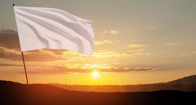 White flag waving in the wind on flagpole against the sunset sky with clouds. White flag is a symbol of surrender.