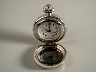 Old pocket watch on a gray background.
