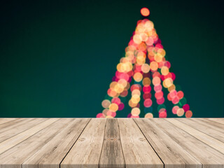 Empty wooden tabletop and blur room with a Christmas tree background, suitable for montage product