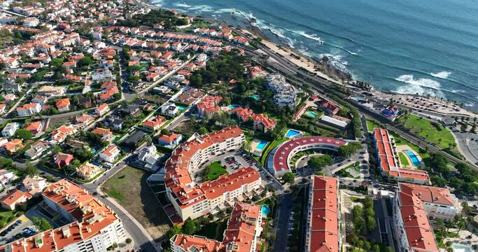 Aerial drone view of Oeiras small town near Lisbon in Portugal. Vacation destination and tourist trap in Europe. Drone flies over the houses near the Atlantic ocean on a sunny summer day.