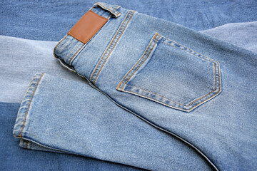 Lots of jeans pants in a stack. Denim background.