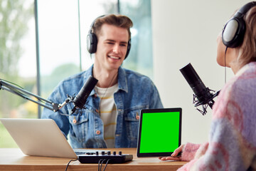 Couple Recording Podcast Or Broadcasting Interview On Radio In Studio At Home With Digital Tablet