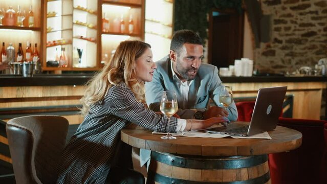 Business meeting of man and woman using laptop in luxury restaurant