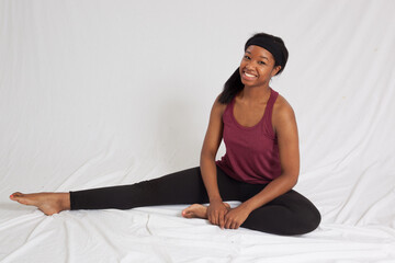 Happy woman in workout gear sitting on a floor