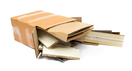 a pile of construction debris (plastic, MDF, aluminum, cardboard) in a brown cardboard box on a white background