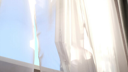 light white tulle sways in the wind, morning fresh clean air fills the room, airing the room. ray of sun lighting through transparent curtain on window. calm slow life concept