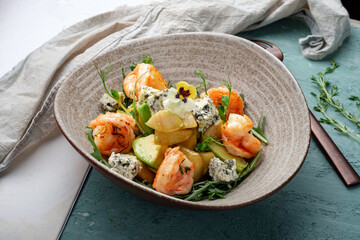 Salad with pear, avocado, shrimp, arugula and gorgonzola cheese. Italian diet salad close up on...