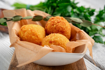 Fried potato croquettes with cheese on a wooden board. Snack with potato balls, close up