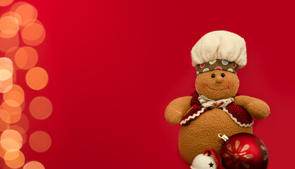 Christmas cookie chef with red bauble and jingle bell design in a red background with yellow lights bokeh