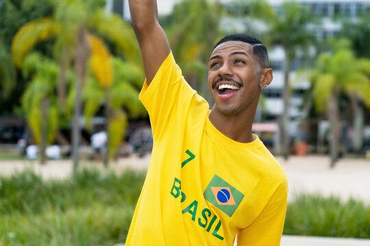 Cheering young man from Brazil with yellow football jersey