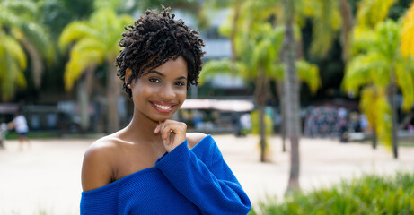 Pretty african american young adult woman with curly hair - obrazy, fototapety, plakaty