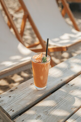 Mango smoothies, yellow fruit juice on white wooden background. Refreshing mango smothie served with oat flakes and physalis.