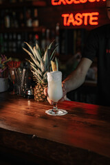 Expert barman is making cocktail at night club.