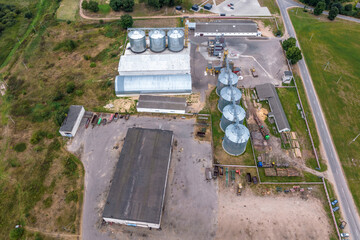aerial view on rows of agro silos granary elevator with seeds cleaning line on huge agro-processing...