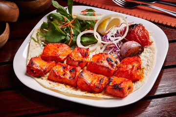 Spicy tandoori Chicken Tikka boti kabab with bread, lemon and salad served in dish isolated on...