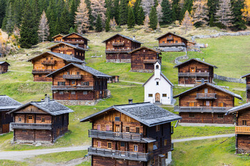 Idyllic group of historic wooden farm houses on a alpine pasture in Austria during autumn