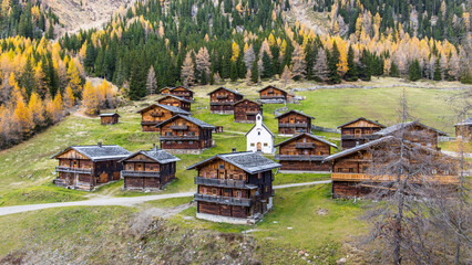 Idyllic group of historic wooden farm houses on a alpine pasture in Austria during autumn
