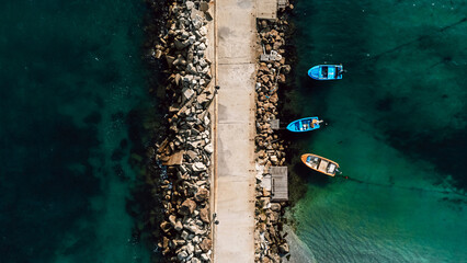 Aerial view of the breakwater in the sea and small boats. Beautiful abstract natural background. 