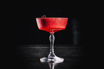 Pink cocktail in glass on the black background