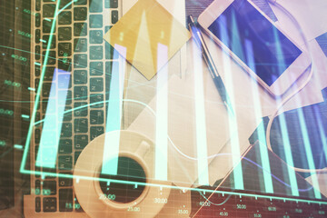 Double exposure of financial chart drawing over table background with computer. Concept of research and analysis. Top view.