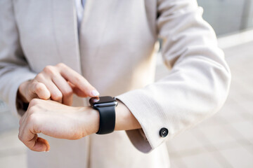 A smartwatch on a woman's hand touches the display with her finger.