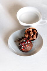 Cocoa bomb in the cup with marshmallows, chocolate hot melts when hot milk is added for creating a...