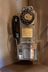 Close Up of Old Antique Rotary Pay Phone in Phone Booth