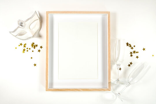 New Year's Eve product mockup. Wall art picture poster print frame mockup with white mask and champagne glasses. Negative copy space.
