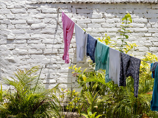 Ropa tendida junto a pared blanca de ladrillos