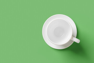 White mug over green background. Empty cup on a saucer closeup. Large teacup mockup for hot...