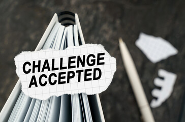 On the table is a notebook on which lies a piece of torn paper with the inscription - Challenge...