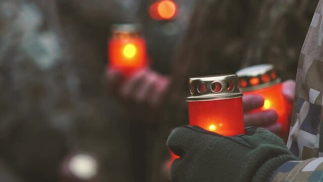 Remembrance day lest we forget. Memorial Day with candles. Commemorative candles are lit. Ukrainian Soldiers in military uniform holding red candles. Servicemen at military parade