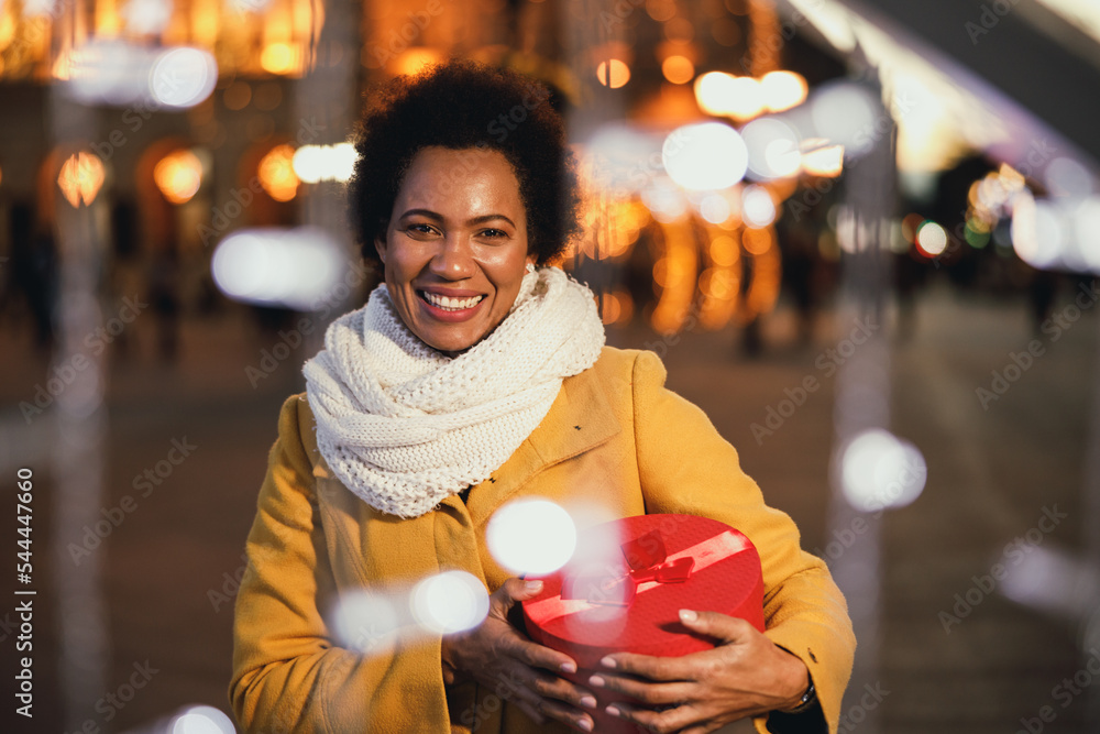 Wall mural black woman with xmas present box in the city