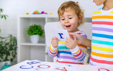 The child learns English letters. Selective focus. - obrazy, fototapety, plakaty