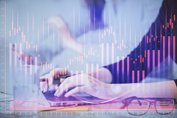Multi exposure of woman hands typing on computer and financial graph hologram drawing. Stock market...