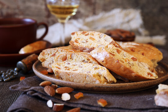 Italian cookies: almond and candied orange cantuccini (biscotti), coffee and glass of white wine