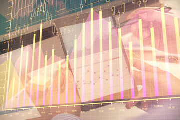 Double exposure of man's hands holding and using a phone and financial chart drawing. Market analysis concept.