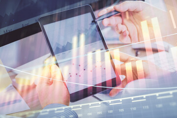 Double exposure of man's hands holding and using a phone and financial chart drawing. Market analysis concept.
