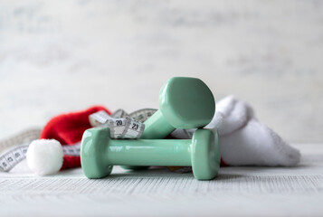 Dumbbells, Santa Claus hat and measuring tape with numbers 2023. Sport and healthy lifestyle concept